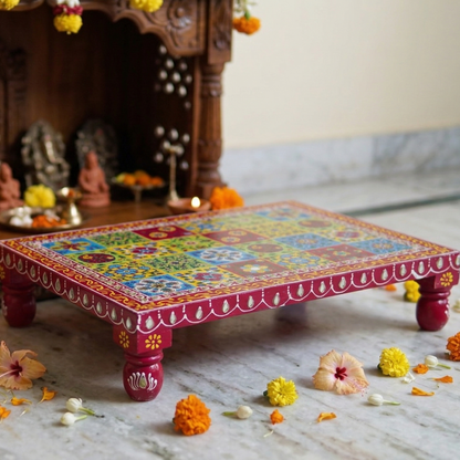 Decorative colorful low table with floral patterns on a marble floor, with a blurred background of decorative items.