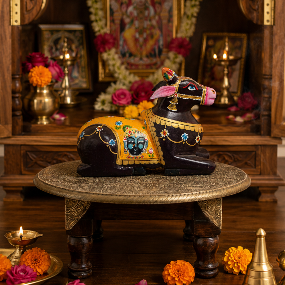 Decorative cow statues on a pedestal with a religious setting in the background