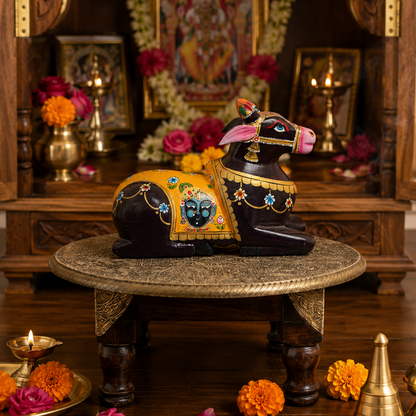 Decorative cow statues on a pedestal with a religious setting in the background