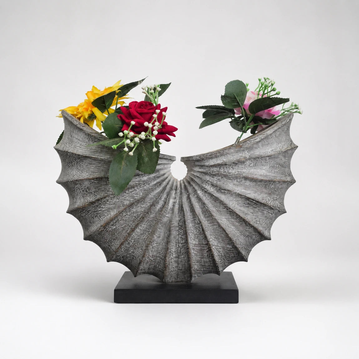 Decorative wooden carved vase shaped like a shell with flowers on a white background