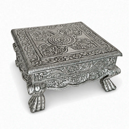 Handcrafted 18x18 inch teak wood pooja chowki with elegant silver finish metal cladding and PU coating. Ideal for God idols, pooja accessories & temple décor.