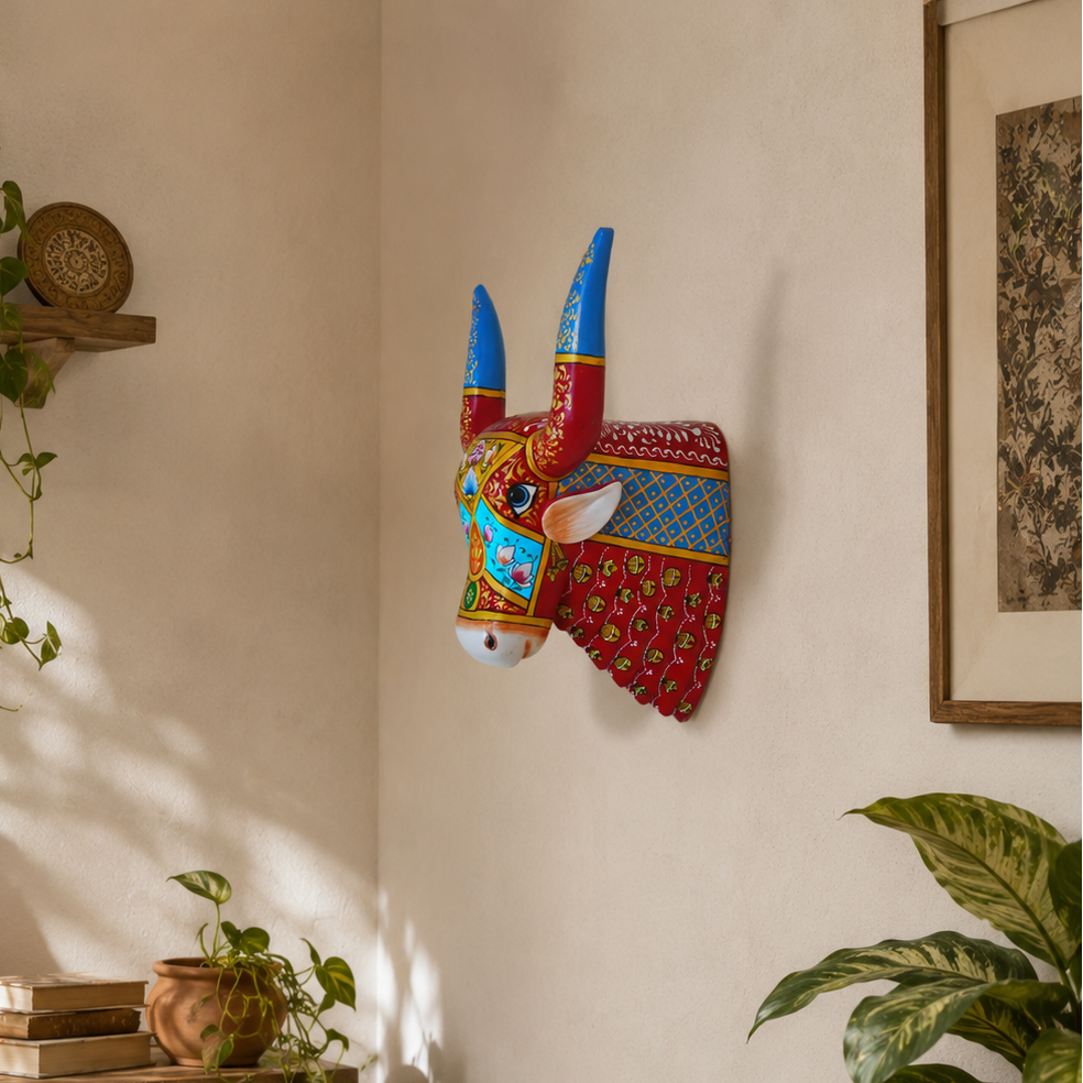 Decorative wall mask of a bull with colorful patterns in a home setting.