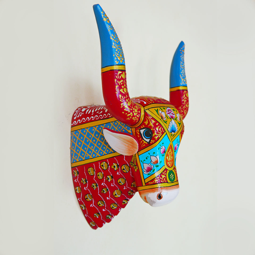 Decorative bull head sculpture with colorful patterns on a white background