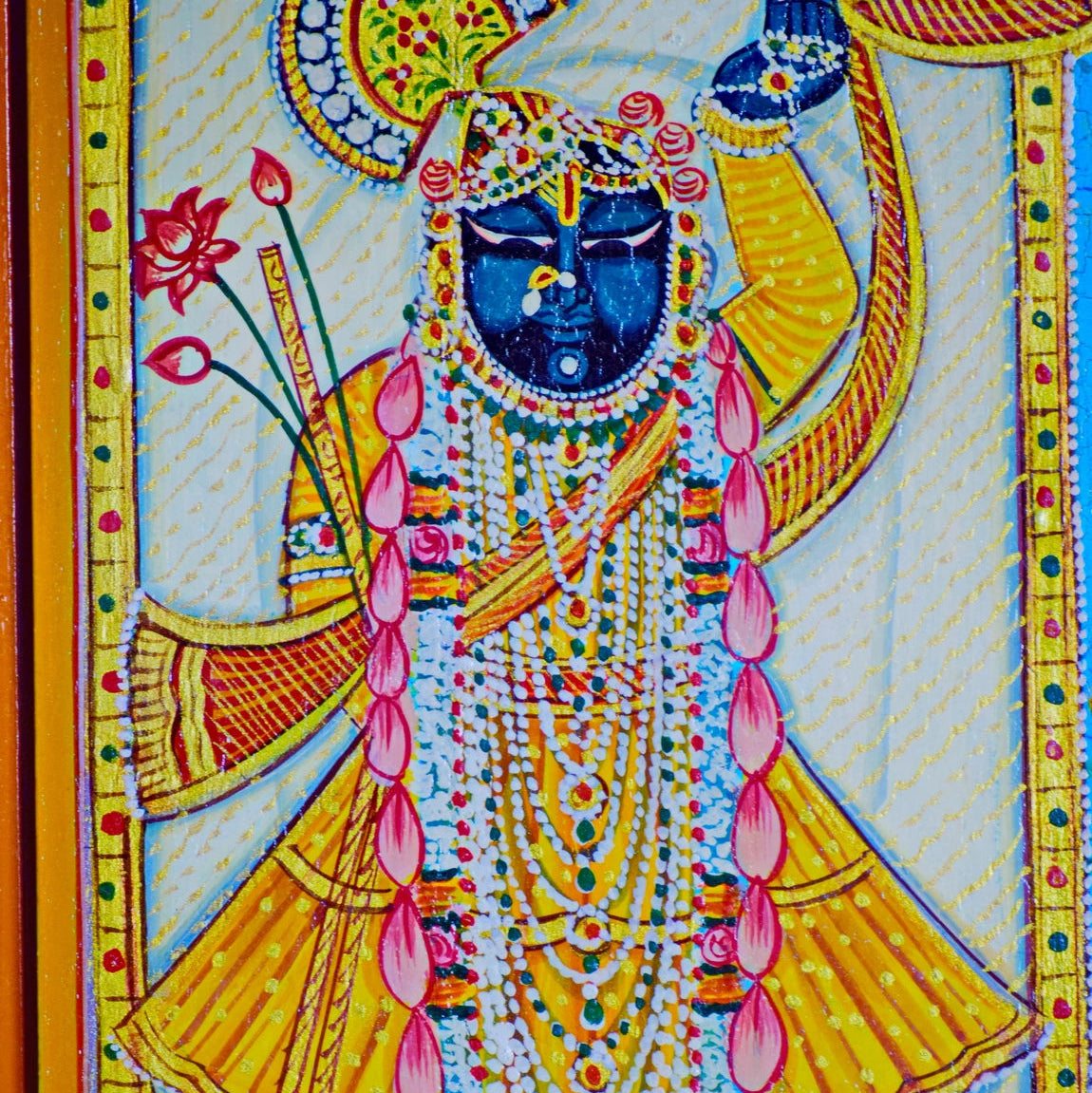 Colorful depiction of aShrinath ji with intricate details and a decorative border.