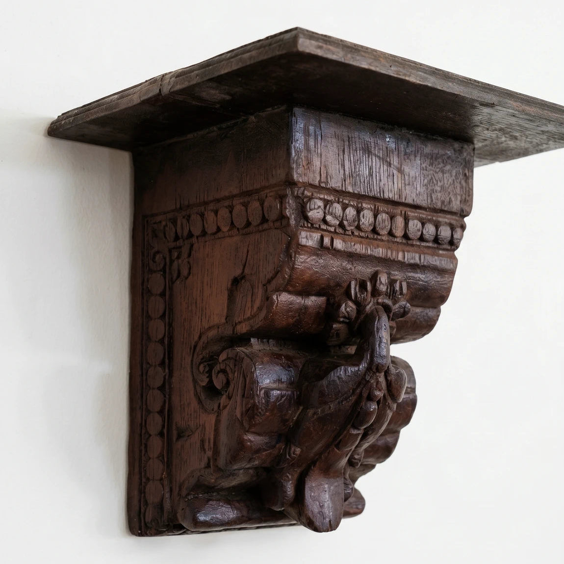 Wooden bracket with intricate carvings on a white background