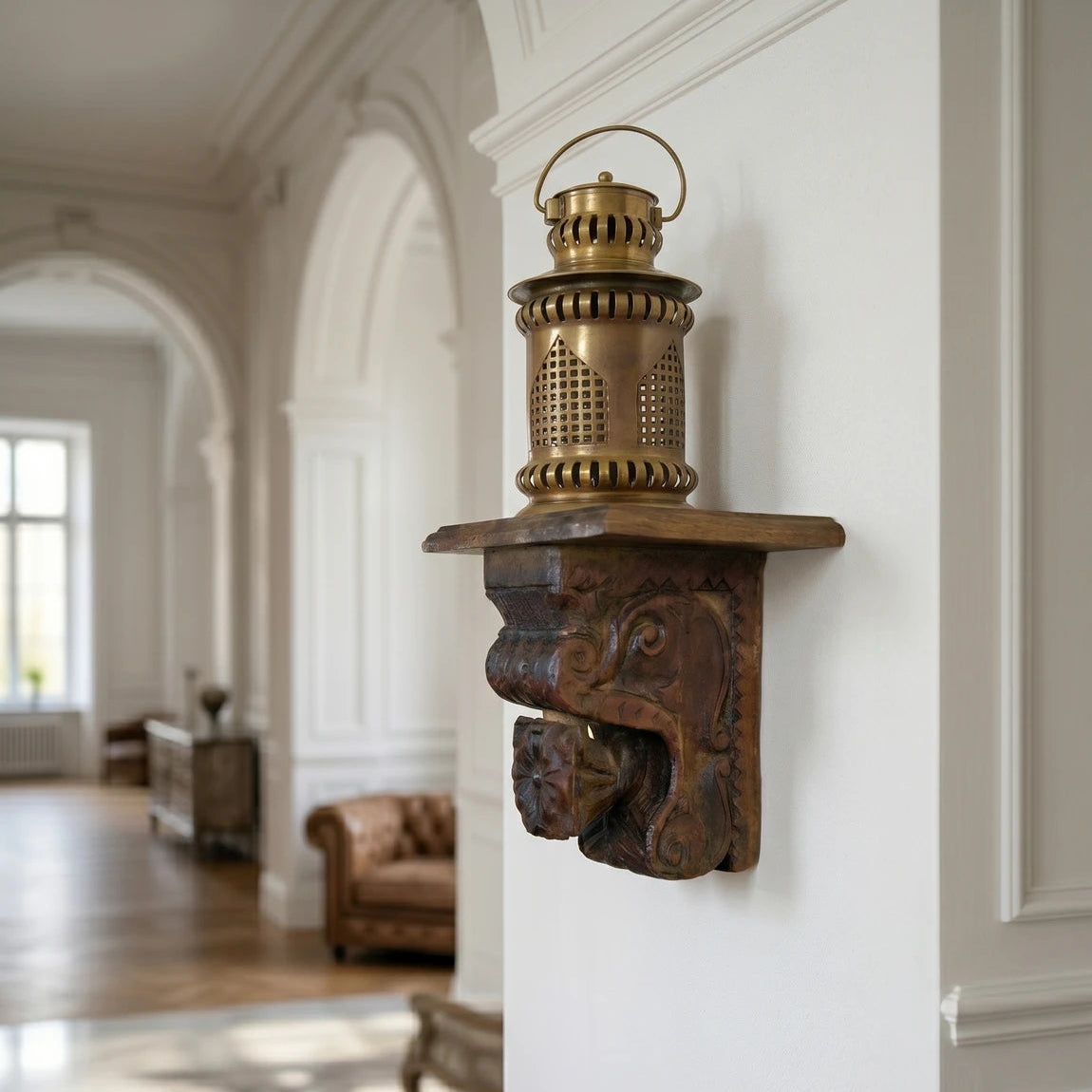 Decorative metal bracket with a lantern on a white wall in an elegant room.